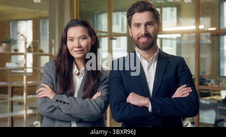 Confident smiling Korean Caucasian businesspeople folding hands crossing arms team business woman man posing looking camera gesture success Stock Photo