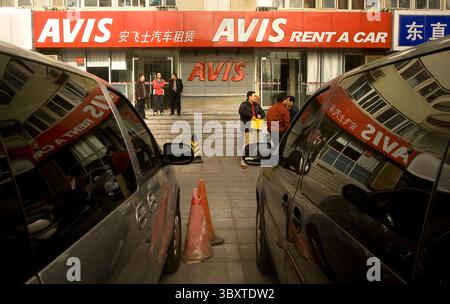 December 1, 2008, BEIJING, CHINA: Chinese men stand in front of an Avis car rental store in Beijing December 1, 2008.   Over the next two years, Avis China - currently the only international car rental brand operating in China - plans to extend the total number of Avis rental locations to 40 by expanding its presence in China from eight to fifteen cities. (Credit Image: © Stephen Shaver/ZUMA Press Wire) Stock Photo