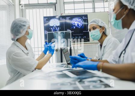 medical students studying brain disease diagnosis through learning from X-ray film. Stock Photo