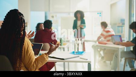 Talking, professor and lecture with students in classroom for college, learning and lesson notes. University, education and teaching with people on Stock Photo