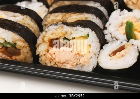 Japanese sushi rolls close up. Fresh maki with rice and nori seaweed. Salmon, egg and vegetables inside. Traditional Asian snack. Stock Photo