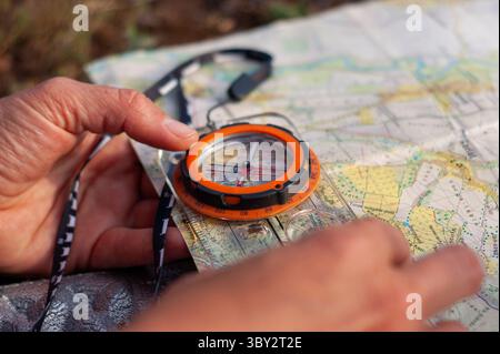 Hands Navigating Using a Compass and Map in an Outdoor Adventure Setting Stock Photo