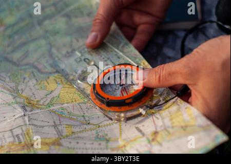 Hands Navigating Using a Compass and Map in an Outdoor Adventure Setting Stock Photo