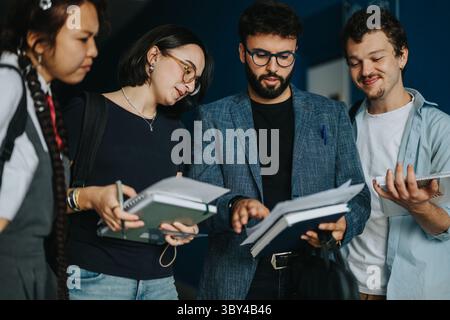 College students engaging in discussion with professor between classes Stock Photo