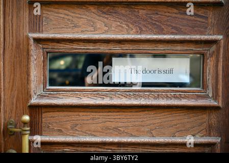 helsinki finland sign on door reads- the door is stiff Stock Photo