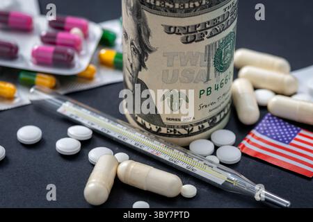 Macro close up of medical pills, thermometer, flag and US dollar bills on a black background. A medical cost concept. Stock Photo