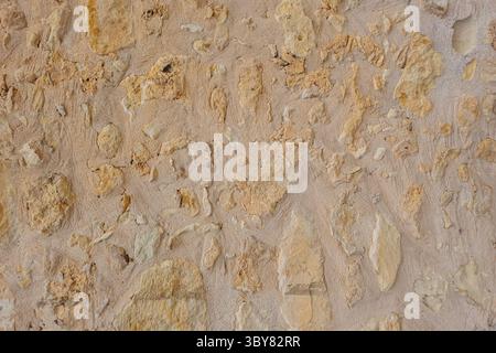 Textured wall in Crete with embedded stones, unique stone wall surface, natural background Stock Photo