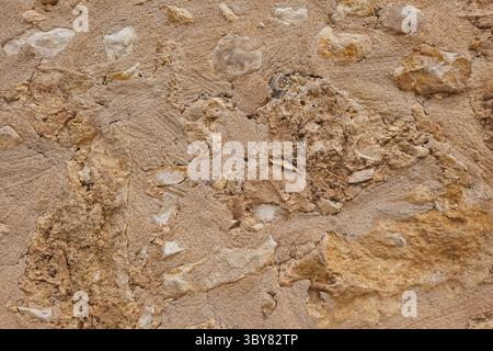 Textured wall in Crete with embedded stones, unique stone wall surface, natural background Stock Photo