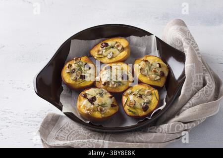 Food, Peaches stuffed with blue cheese with nuts and rosemary in a baking dish on a light gray background, top view. Delicious gourmet dessert Stock Photo