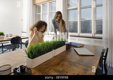 Women collaborating on a digital project in a modern workspace focused on health solutions Stock Photo