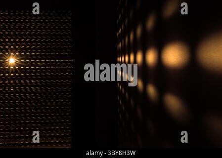 Sunrise through blinds creating an abstract effect. The morning sun shining through window blinds causing a golden pattern Stock Photo