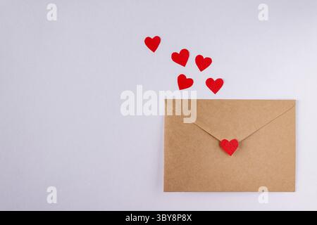 Craft envelopes with red paper hearts on white background, copy space Stock Photo