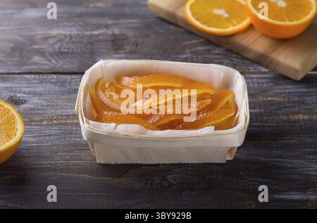 Food, Wicker birch basket with candied oranges and fresh juicy oranges on wooden background Stock Photo