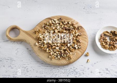 Food, Wooden board with chopped walnut on light blue background, top view Stock Photo