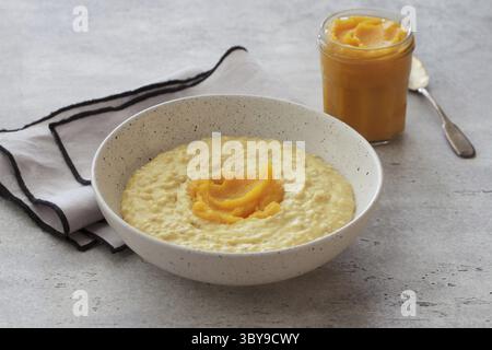 Food, Bowl of oatmeal with pumpkin on a gray textured background. Delicious healthy homemade breakfast Stock Photo