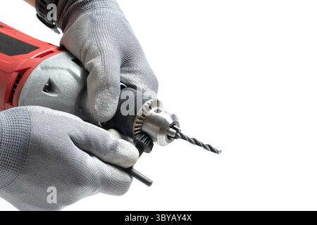 Closeup an electric drill in hands worker in gray gloves on white background Stock Photo