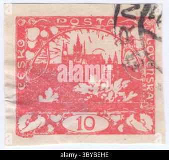 CZECHOSLOVAKIA - 1918 December 18: 10 haléř rose postage stamp depicting view of Prague Castle in Hradcany at Prague, capital of Czechoslovakia. Prague Castle is a castle complex in Prague, Czech Republic serving as the official residence and workplace of the president of the Czech Republic. Built in the 9th century, the castle has long served as the seat of power for kings of Bohemia, Holy Roman emperors, and presidents of Czechoslovakia. The Bohemian Crown Jewels are kept within a hidden room inside it Stock Photo