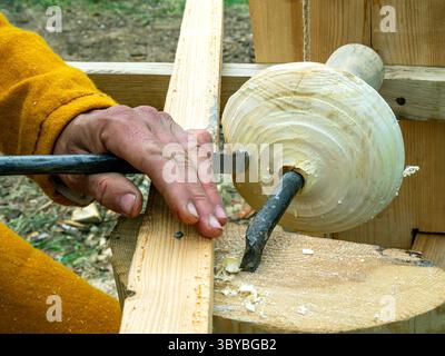 Making a wooden bowl on a replica of a medieval lathe. Rusborg Historical Reenactment Festival Stock Photo