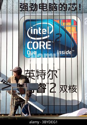 December 18, 2009, BEIJING, CHINA: Two Chinese workers install a massive computer billboard, featuring IBM laptops bundled with Microsoft software, at a electronics store in Beijing on December 18, 2009.  China will become Microsoft's biggest market within the next seven years, according to Bill Gates. (Credit Image: © Stephen Shaver/ZUMA Press Wire) Stock Photo