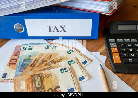Much folders with tax documents. Euro money bills, pen, calculator and paper on the table. Office work for business. Stock Photo