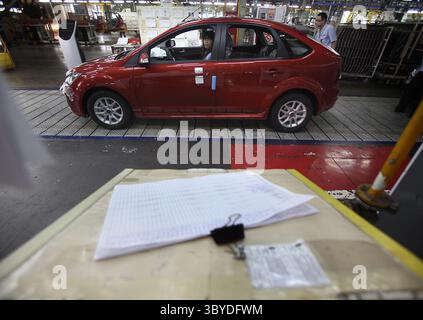 Chinese factory workers assemble Ford Focus cars on the assembly line ...