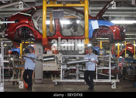 Chinese factory workers assemble Ford Focus cars on the assembly line ...
