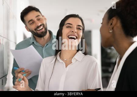 Three colleagues enjoy process of working together in positive atmosphere Stock Photo