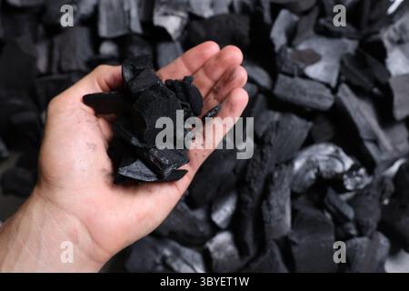 Man with black coals over pile, above view Stock Photo