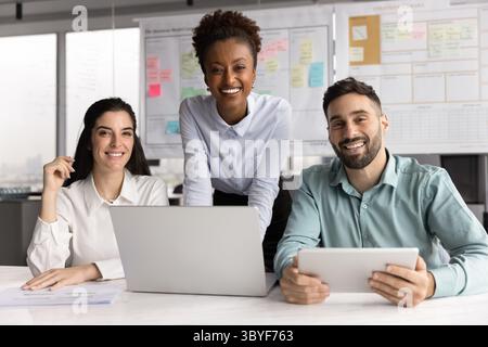 Portrait of three diverse colleagues posing for camera in office Stock Photo