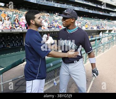 Seattle Mariners' Eugenio Suárez, right, is greeted by third base coach ...