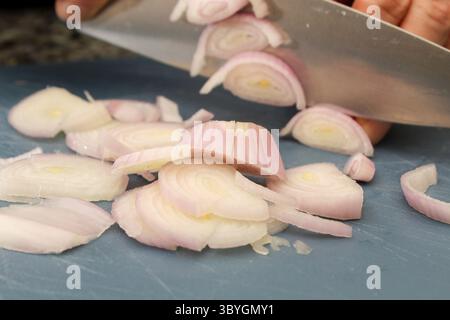 Close-Up of Slicing Shallots on a Cutting Board During Food Prep Stock Photo