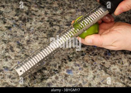 Close-Up of Fresh Lime Being Zested with a Microplane Stock Photo