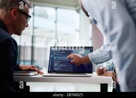 Skilled Programmers Collaborating On Software Development In Modern Office Environment. Stock Photo