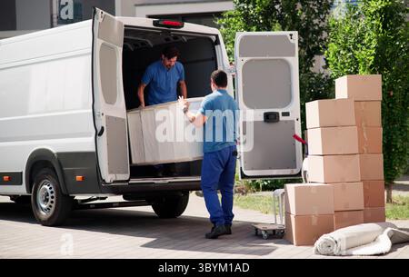 Moving Crew Unloading Furniture From Truck For House Relocation Service Stock Photo