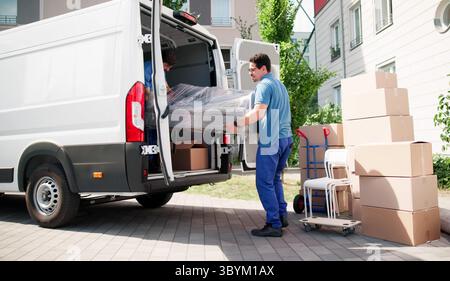 Truck Driver Delivers Sofa For Home Furniture Delivery Service Today Stock Photo