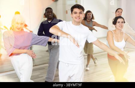 Cheerful guy practicing modern vigorous dance with group Stock Photo