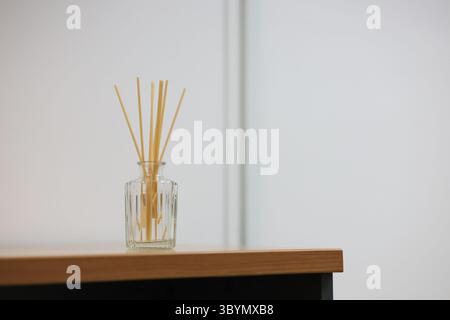 Reed diffusers in perfume bottles are placed on the table. Reed diffusers help create a good atmosphere for a place. Stock Photo