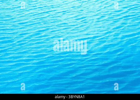 Water background. Blue water, ripples and highlights. Texture of water surface and tiled bottom. Stock Photo