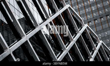 Architectural abstract. Generic modern building exterior in black and white with orange accents. Tubular framework over glass. Stock Photo