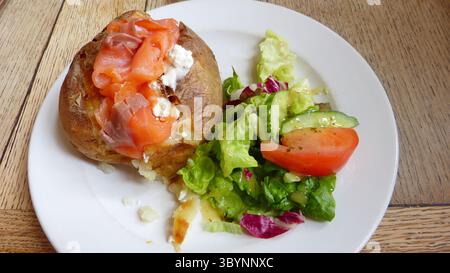 Baked potato with smoked salmon cream cheese and salad Stock Photo