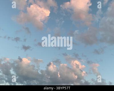 A stunning scene of fluffy clouds drifting across a bright blue sky, creating a picturesque and serene atmosphere. Stock Photo