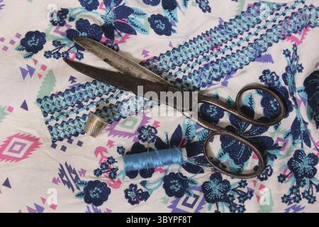 Vintage Embroidered Fabric With Spool of Blue Thread and Thimble Stock Photo