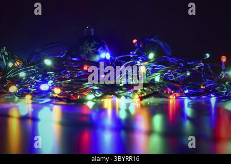 Christmas blurred lights on black background with copy space. Abstract colorful reflections of bulbs on a Christmas tree Stock Photo