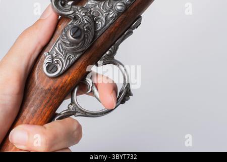 Finger on a trigger of an old decorative flintlock pirate pistol Stock Photo