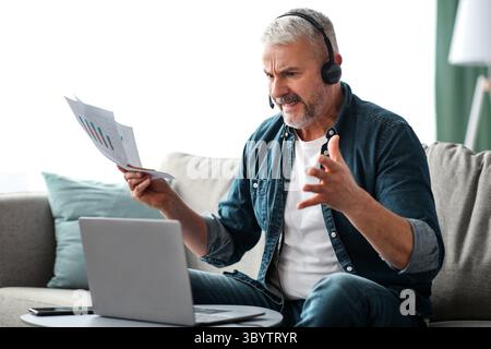 Furious senior businessman having video call with assistant Stock Photo