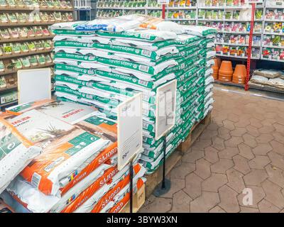 Porsgrunn, Norway - April 06, 2025: Gardening supplies arranged in a shop featuring colorful bags of soil and terracotta pots, creating an inviting at Stock Photo