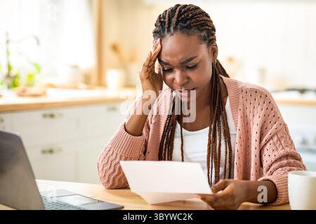 African American Female Freelancer Having Stress While Working With Papers At Home Stock Photo