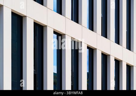Modern office facade with white vertical framing and blue glass Stock Photo