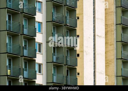 Old-style tower block with repeated green balconies and contrasting pale surfaces Stock Photo