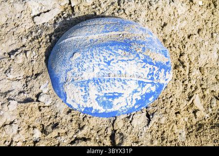 Hastily abandoned construction helmet in the sand Stock Photo